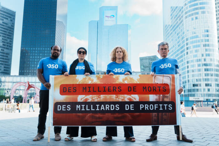 Des militant·es de 350.org déploient une banderole à La Défense, à proximité du siège de TotalEnergies, pour dénoncer la responsabilité des géants des énergies fossiles dans la crise climatique et exiger une taxation plus forte de leurs profits le 22 juillet 2026 – © Rémy El Sibaïe/350.org