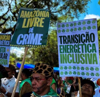 Participantes de mobilização pela proteção da floresta seguram cartazes pela transição energética, nas ruas de Belém, durante a Cúpula da Amazônia. Foto: @nayjinknss @anamendes_anamendes