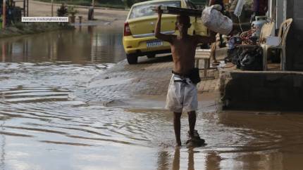 Morador cruza área alagada no Rio: enchentes cada vez mais graves são uma das faces mais visíveis da injustiça climática