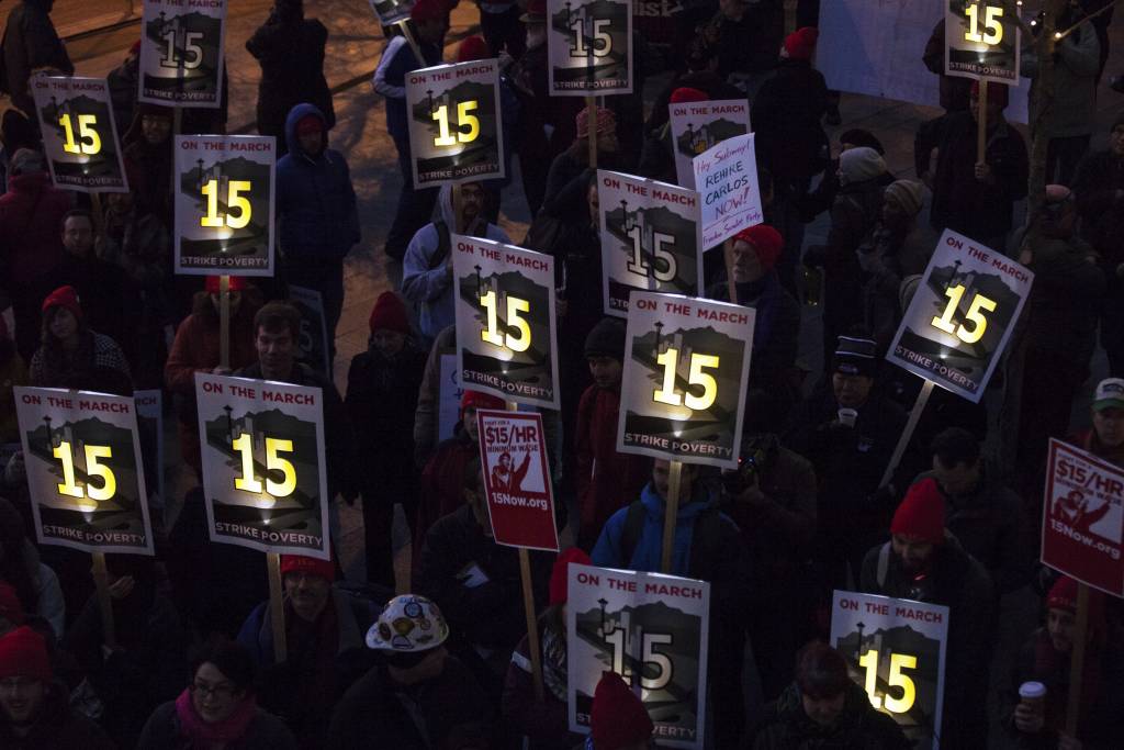 Demonstrators rally to raise the hourly minimum wage to $15 for fast-food workers at City Hall in Seattle