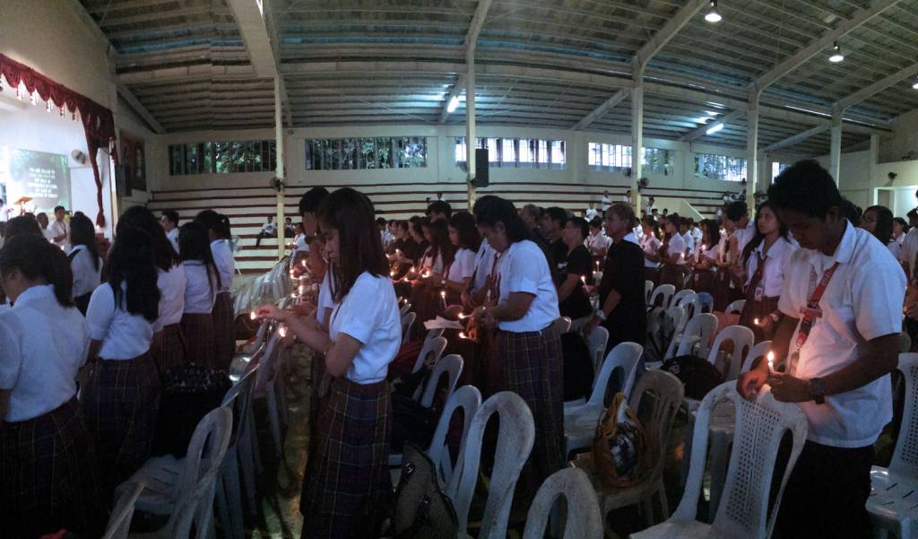 Students of Sacred Heart College, light candles to shine light in their struggle for a coal-free Quezon. Photo: Chuck Baclagon
