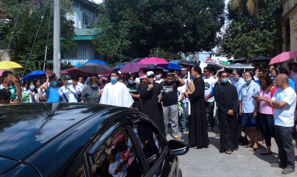 Fr. Raul Enriquez, pleads with the officials to exit their vehicles and speak with the crowd. Photo: Fread De Mesa