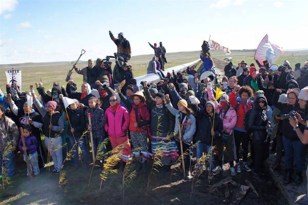 Women and children plant willow trees and corn along the pipeline route. Photo: Indigenous Environmental Network