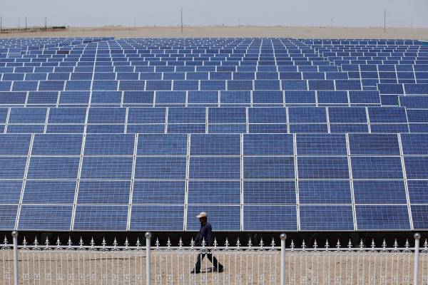 DUNHUANG, GANSU - JULY 21: A Chinese worker walks near the solar modules of a newly installed 100MW photovoltaic on-grid power project on July 21, 2010 in Dunhuang of China's northwest Gansu Province. The government is tendering for bids to develop 13 solar projects with a combined capacity of 280MW in the western regions. The Chinese government has set a target to install 20GW of solar energy capacity and 100GW of wind power by 2020. (Photo by Feng Li/Getty Images)