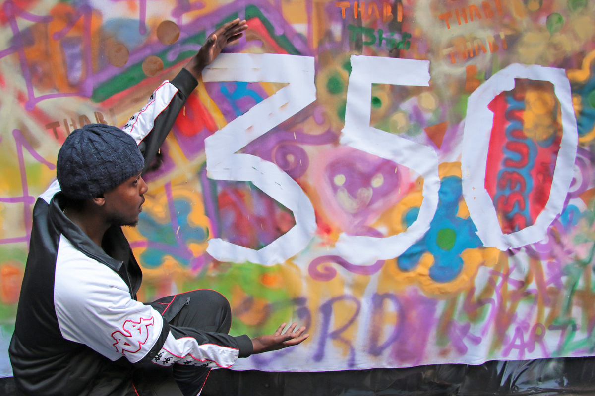 man displaying hand painted 350 banner