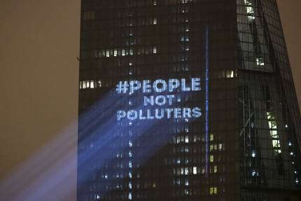 The Koala Kollectiv projected "People not Polluters" onto the side of the European Central Bank