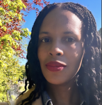 Photo of 350 US Campaign Manager Candice Fortin. She is a Black woman with long hair and red lipstick, pictured outside by some trees 