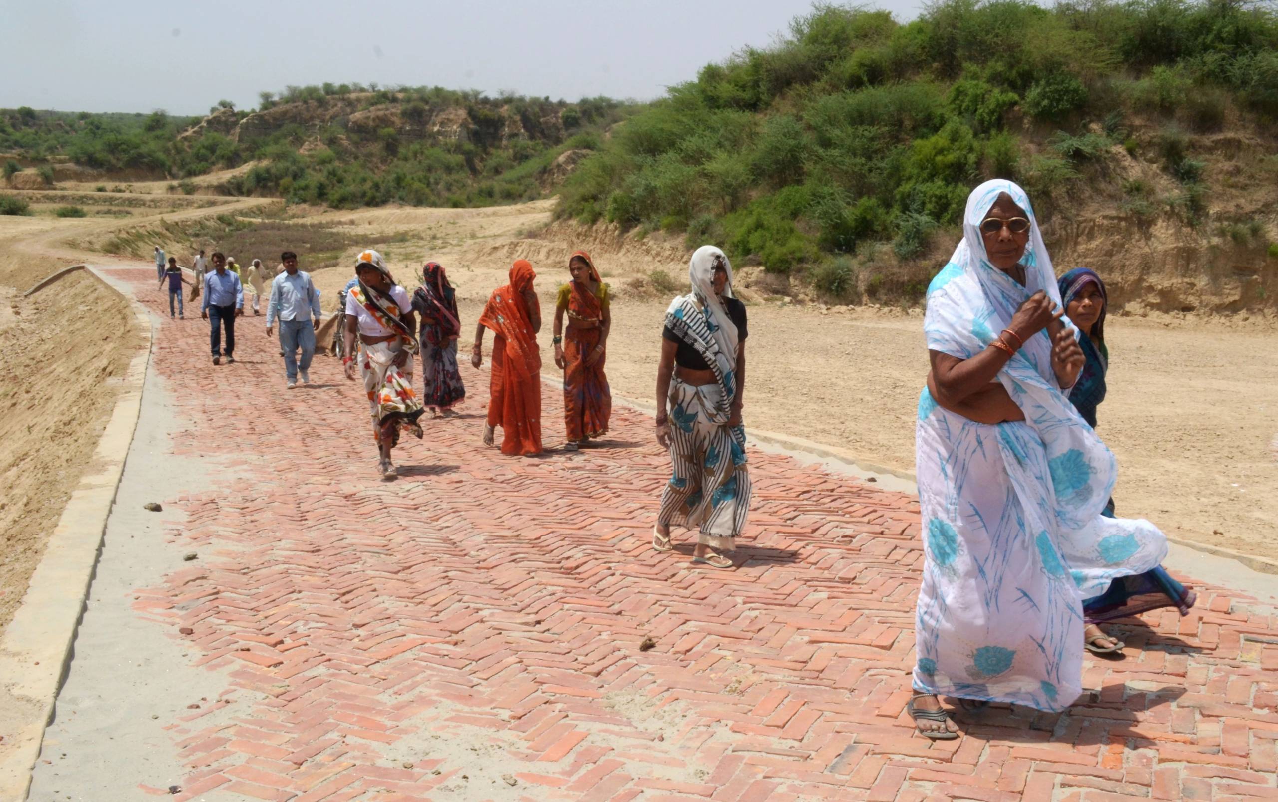 Community members walk through the parched Etawah district of Uttar Pradesh, India. Drought conditions, prevail in these regions, exacerbated by climate change